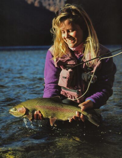wendy gunn nice rainbow Woman holding a trout in river.